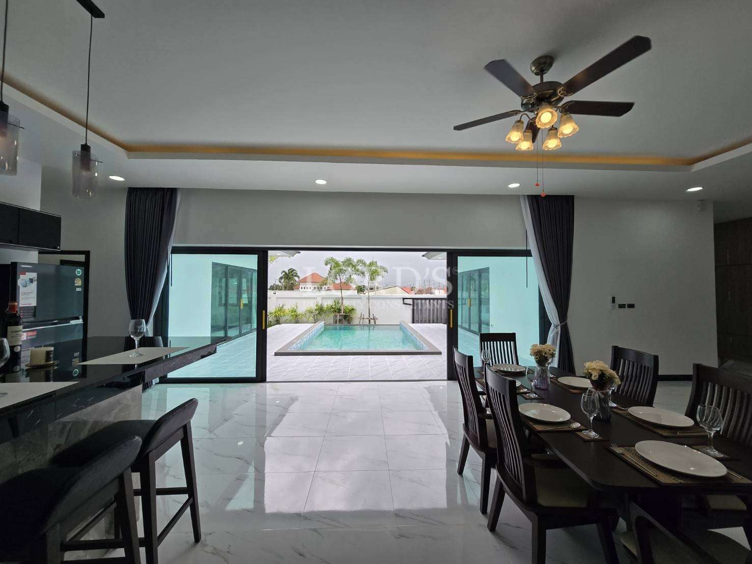 Living area with dining table and pool view