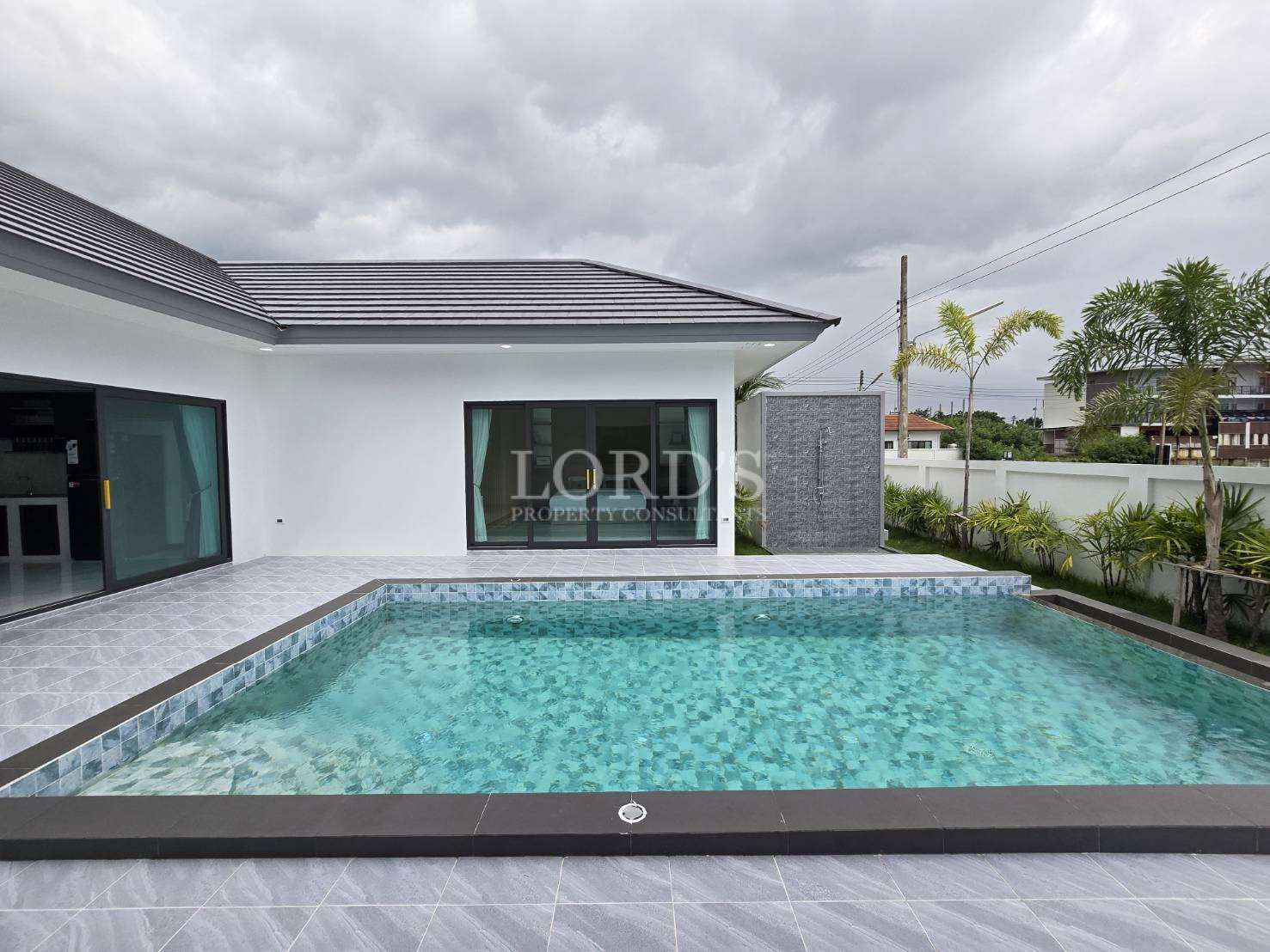 Poolside with villa and tiled deck