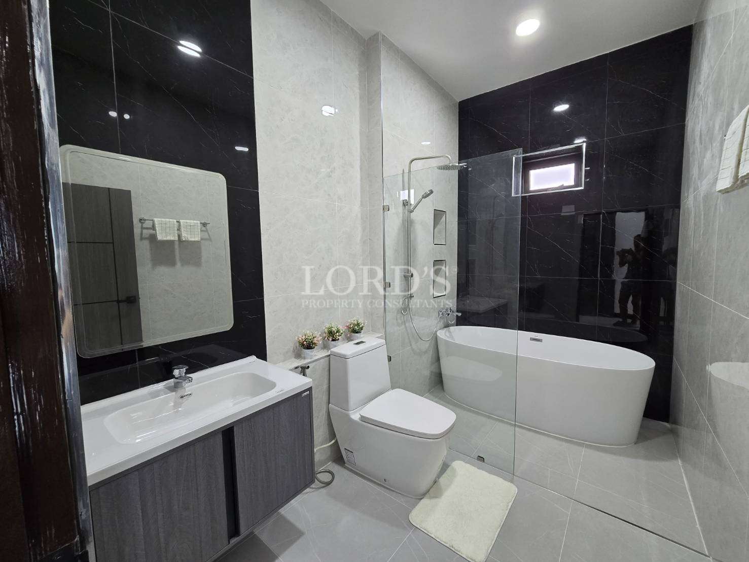 Bathroom with bathtub and dark tile wall