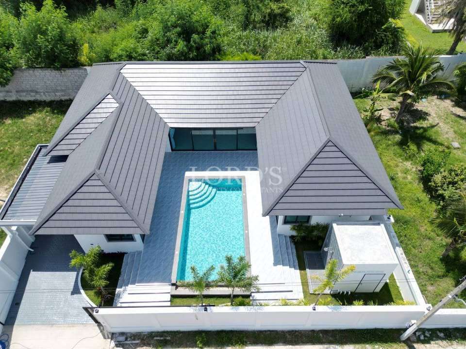 Aerial view of villa with pool and roof design