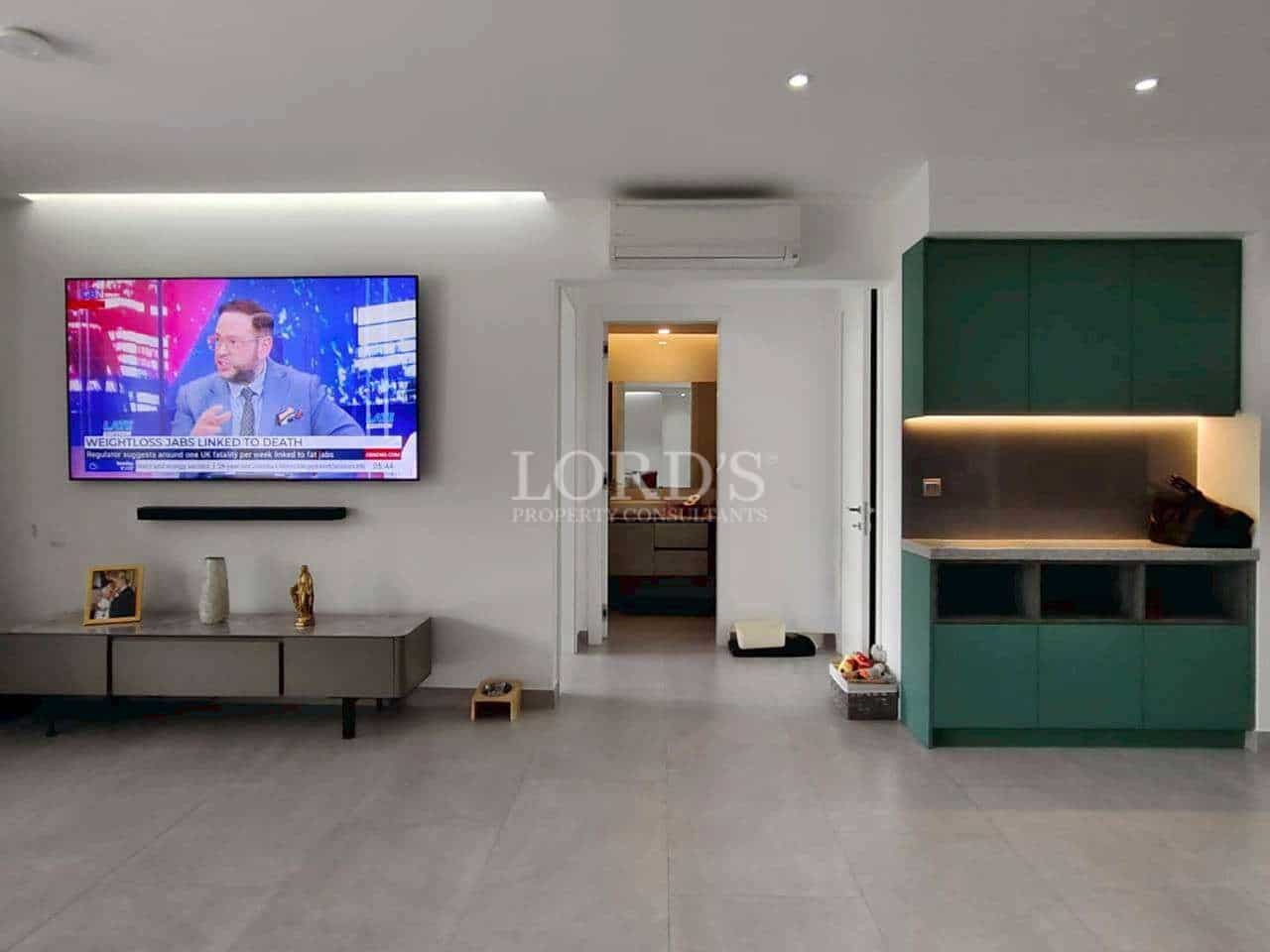 Modern living room with television and kitchen