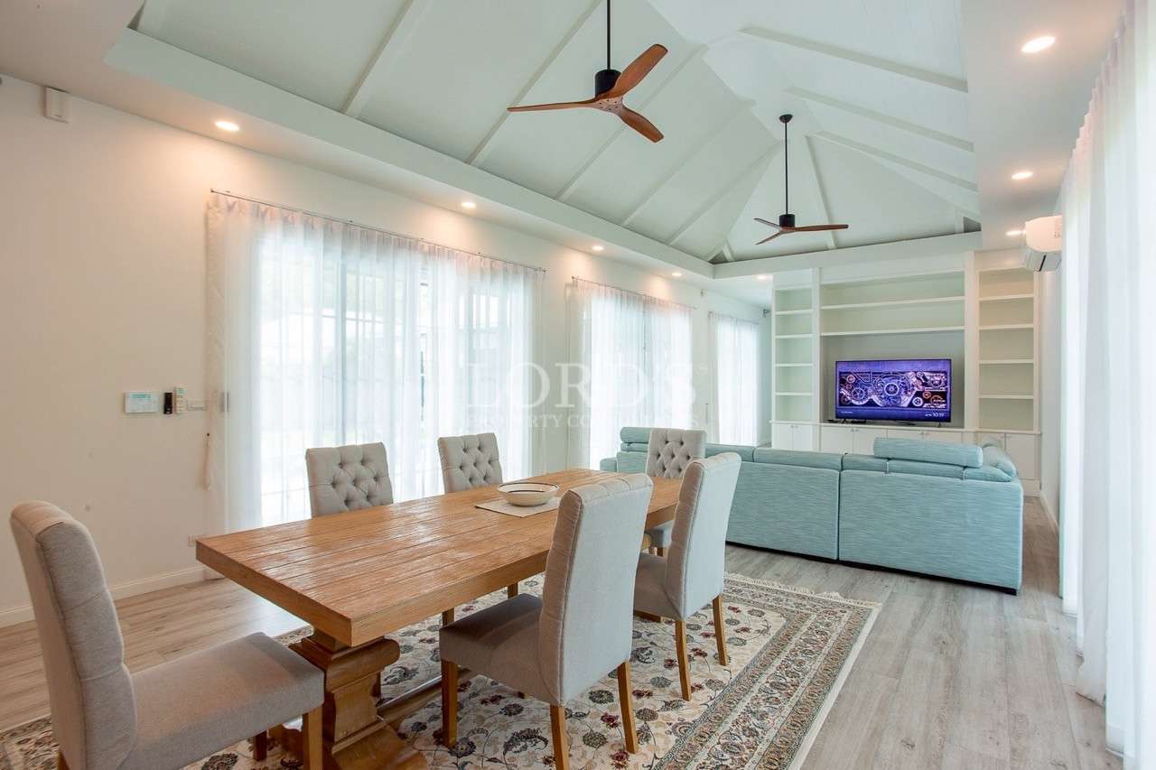 Open-plan dining and living room with wooden table and sectional sofa