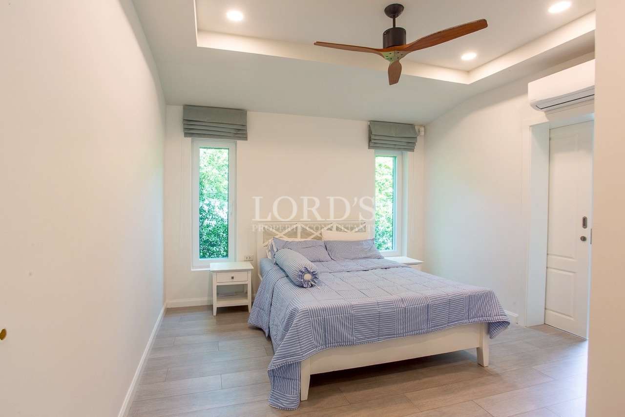 Bright modern bedroom with ceiling fan and large windows