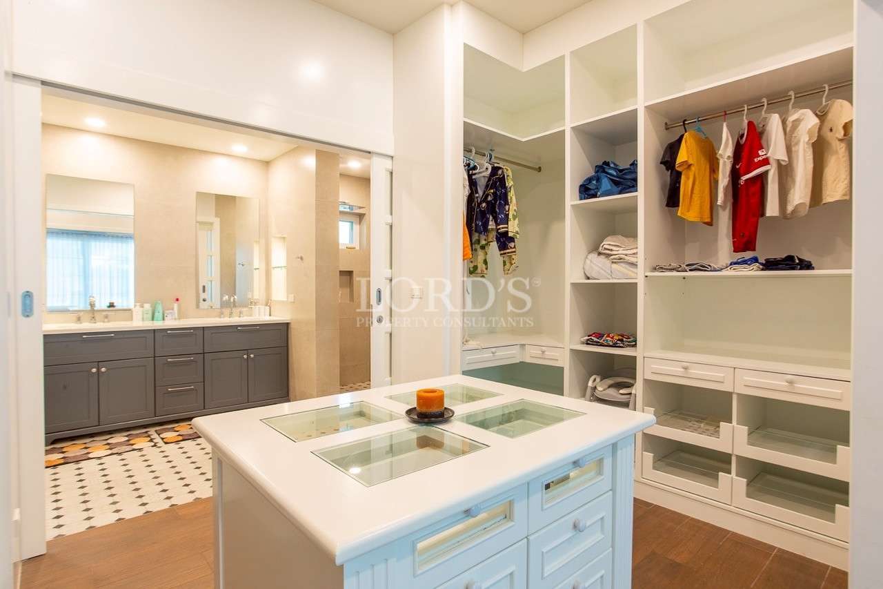 Walk-in closet with built-in shelves and ensuite bathroom vanity