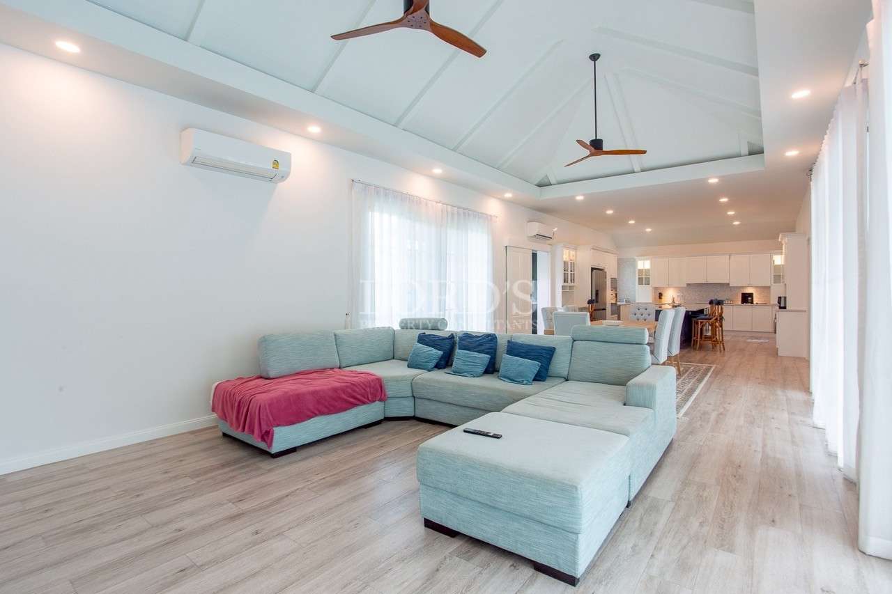 Spacious open-plan living room with sectional sofa and vaulted ceiling.
