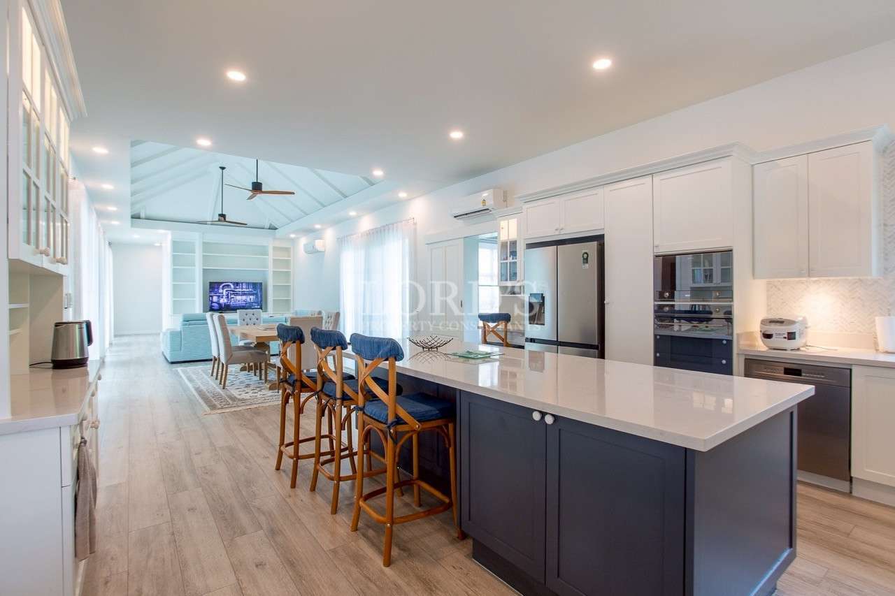 Bright open-plan kitchen and living area with large island and modern appliances.