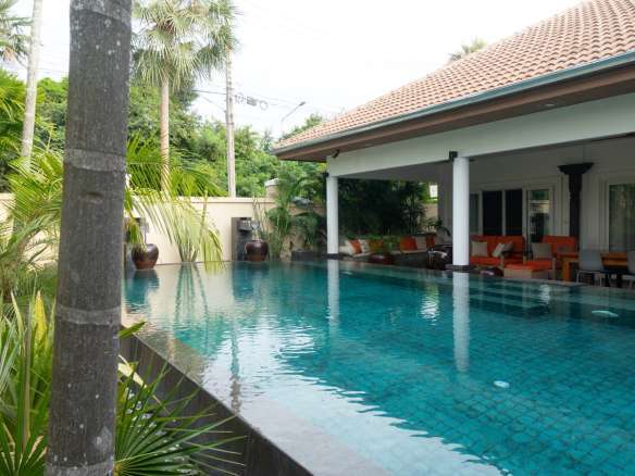 Swimming pool with villa and greenery