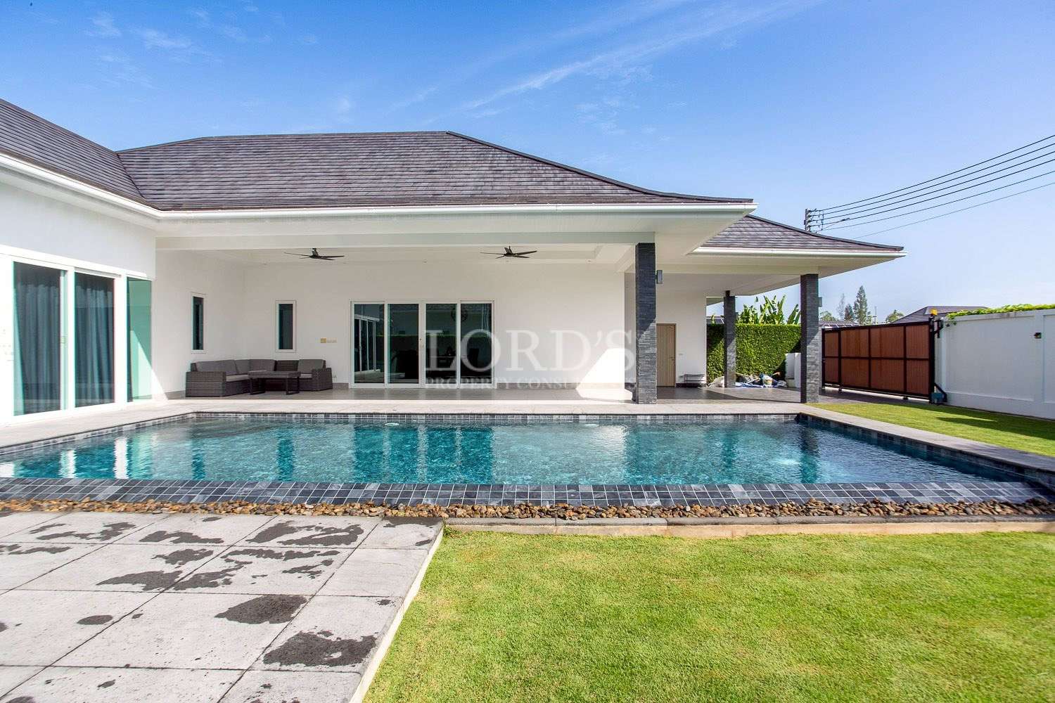 Pool with lawn and villa exterior