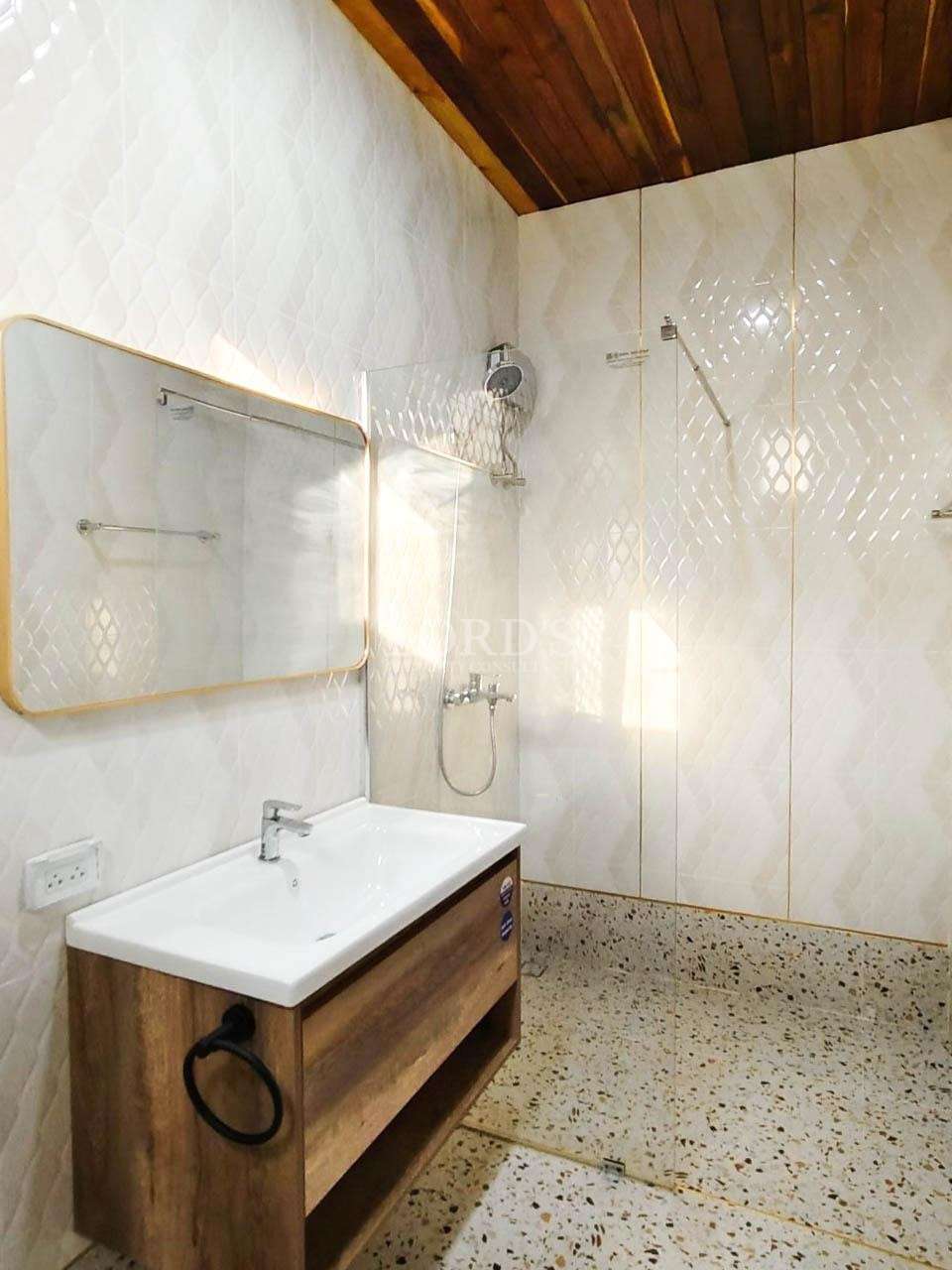 Bathroom with sink and mirror and tiled wall
