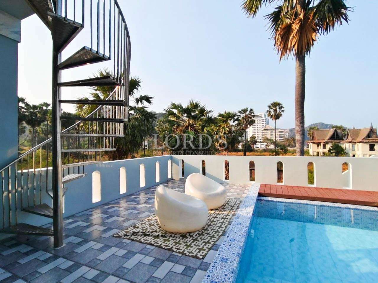 Poolside area with seating and spiral staircase