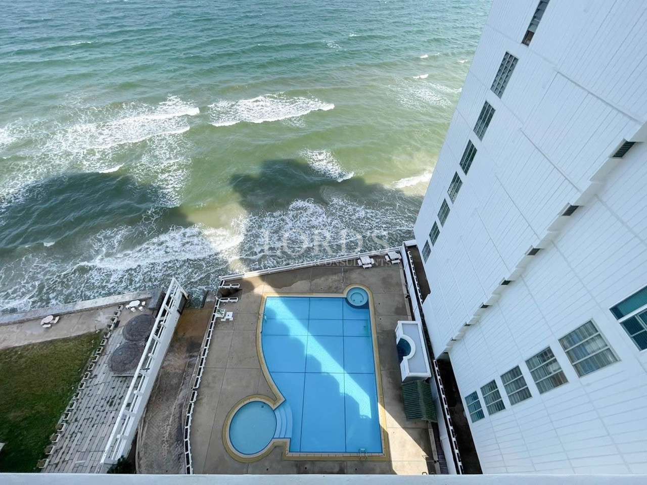Pool beside building with ocean view
