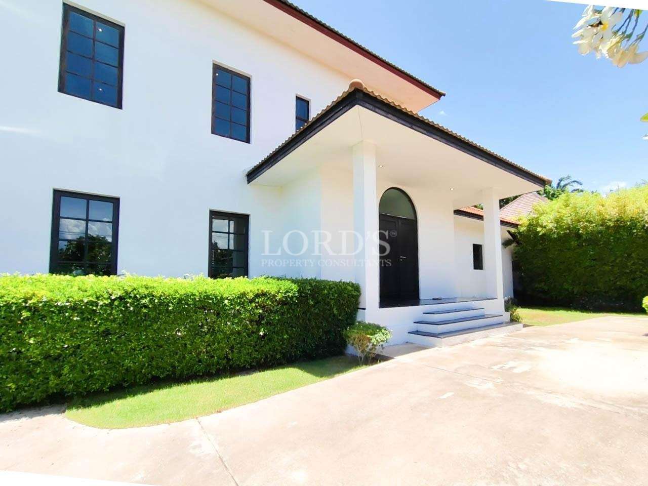 Exterior villa wall with greenery and driveway