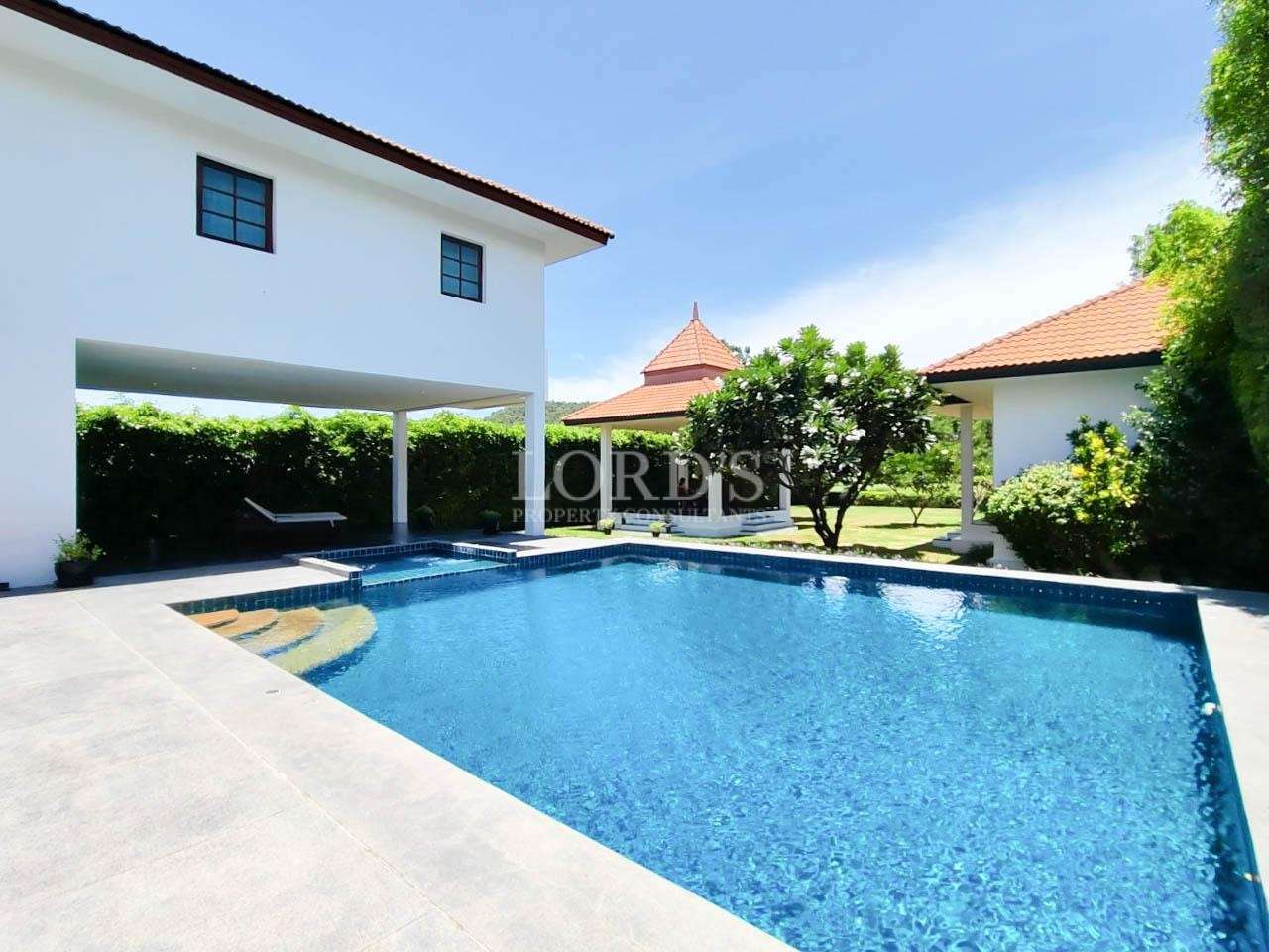 Pool with villa exterior and clear sky