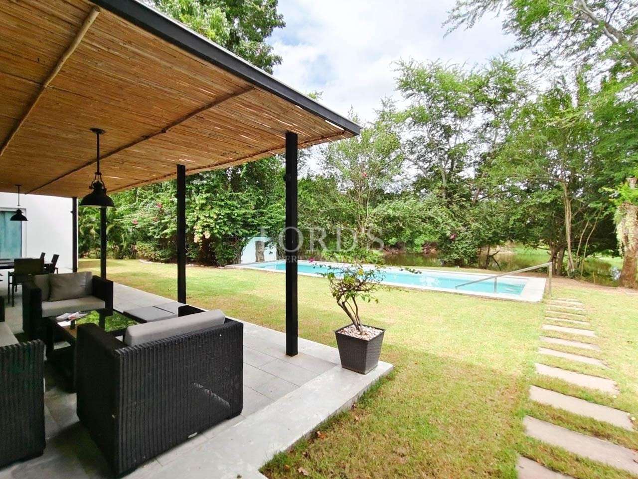 Outdoor lounge with roof and garden view