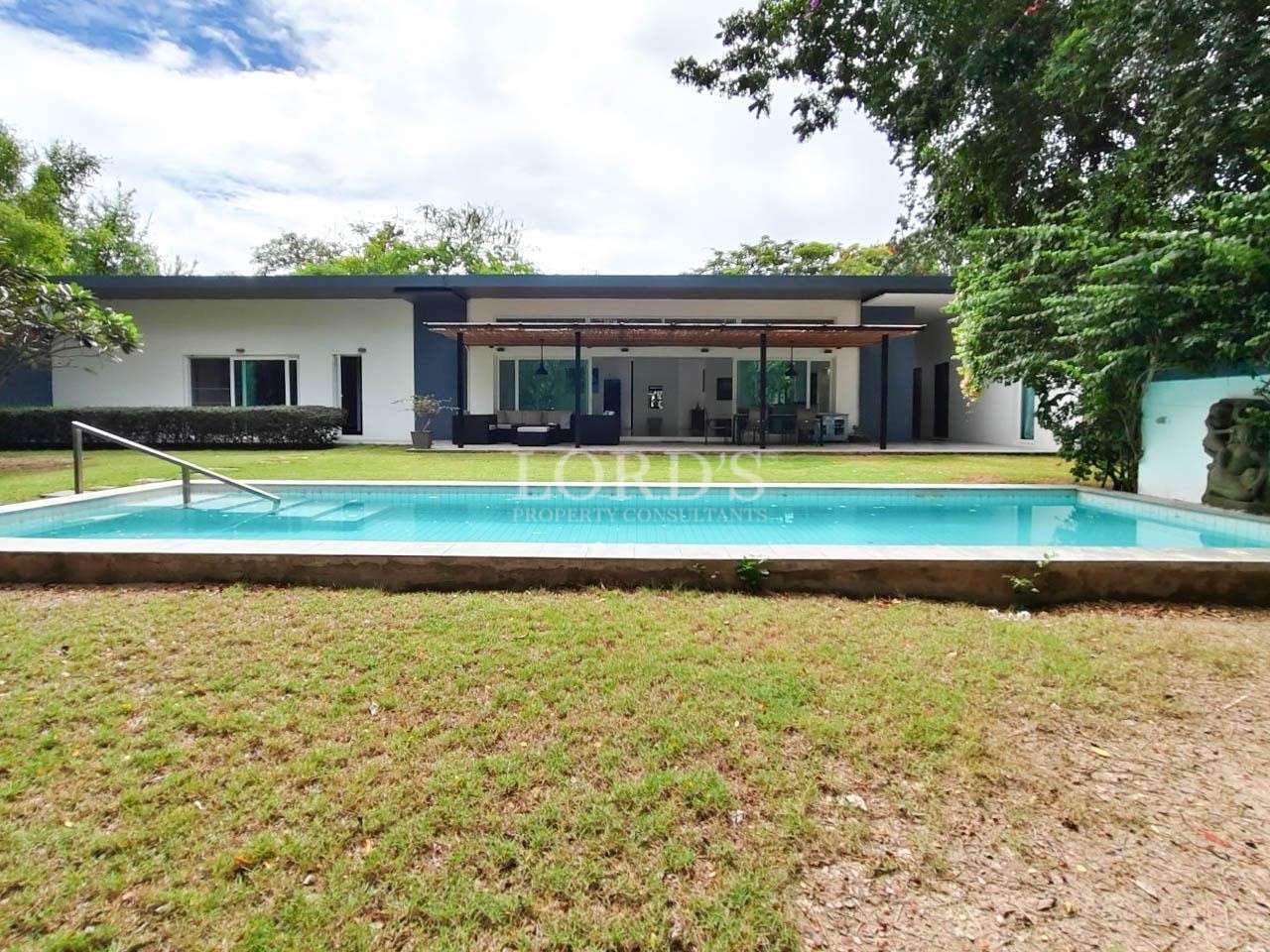 Long swimming pool with house view