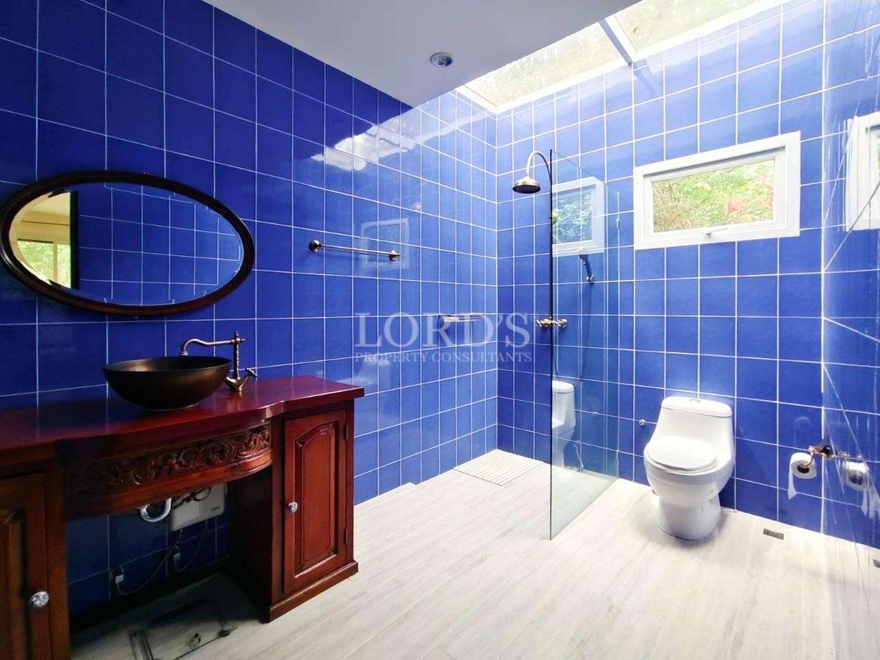 Blue tiled bathroom with shower and toilet