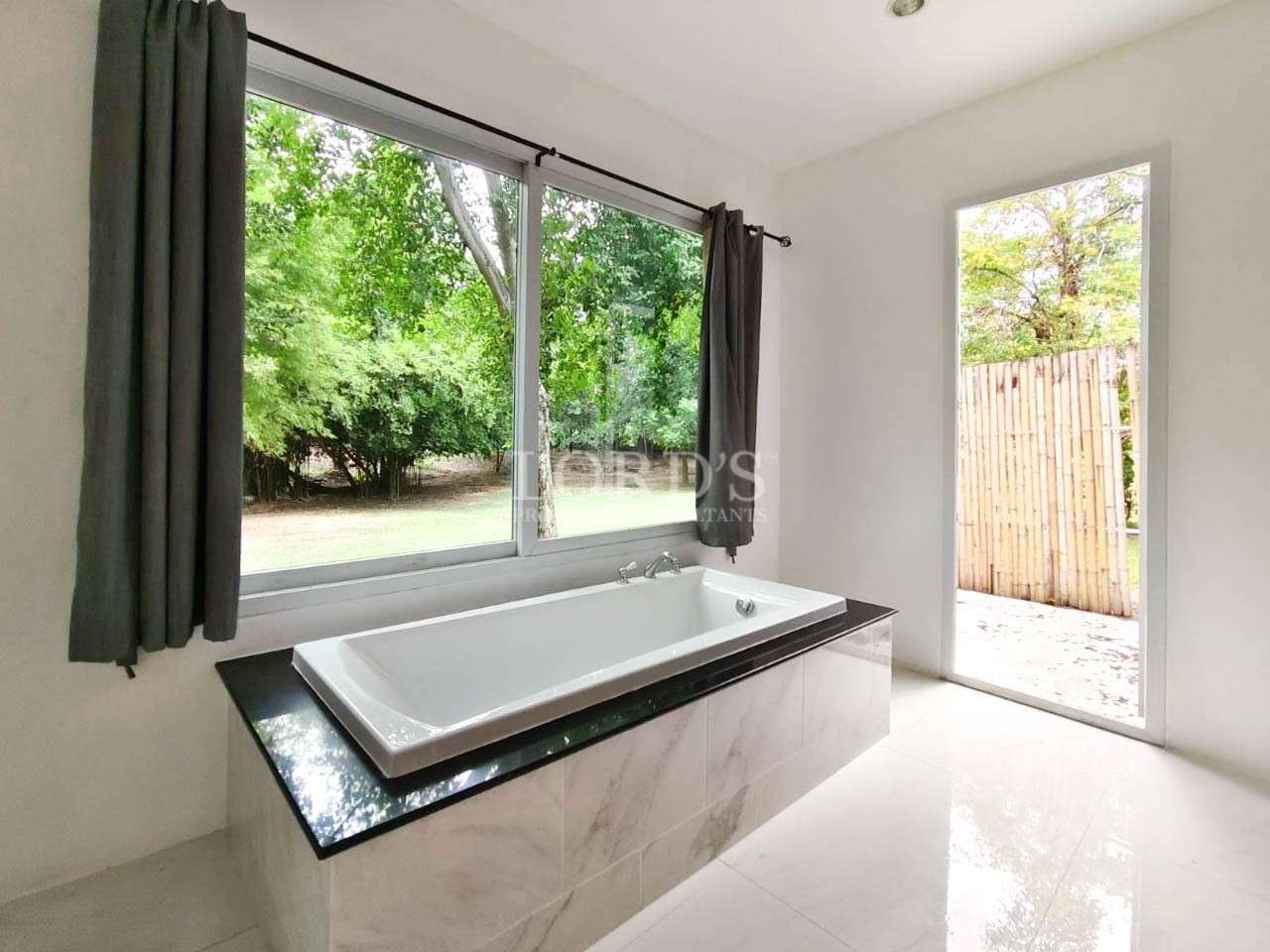 Bathroom with large window and bathtub