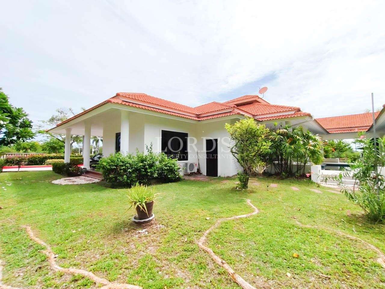 Luxury single-story villa with red tile roof and landscaped garden