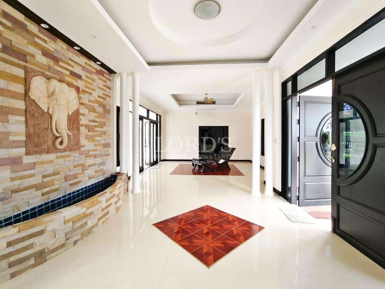 Luxury villa entrance hall with decorative elephant wall art and white columns
