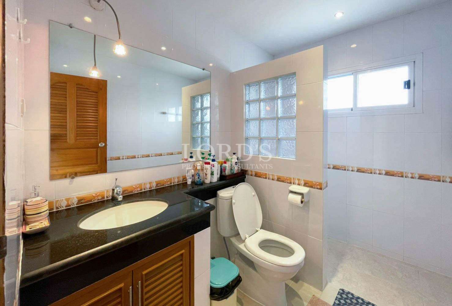 Bathroom with vanity and tiled walls