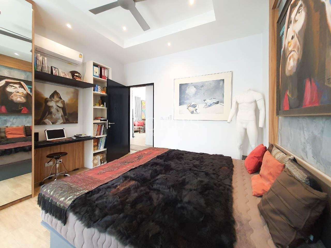 Bedroom with dark bedding and artwork