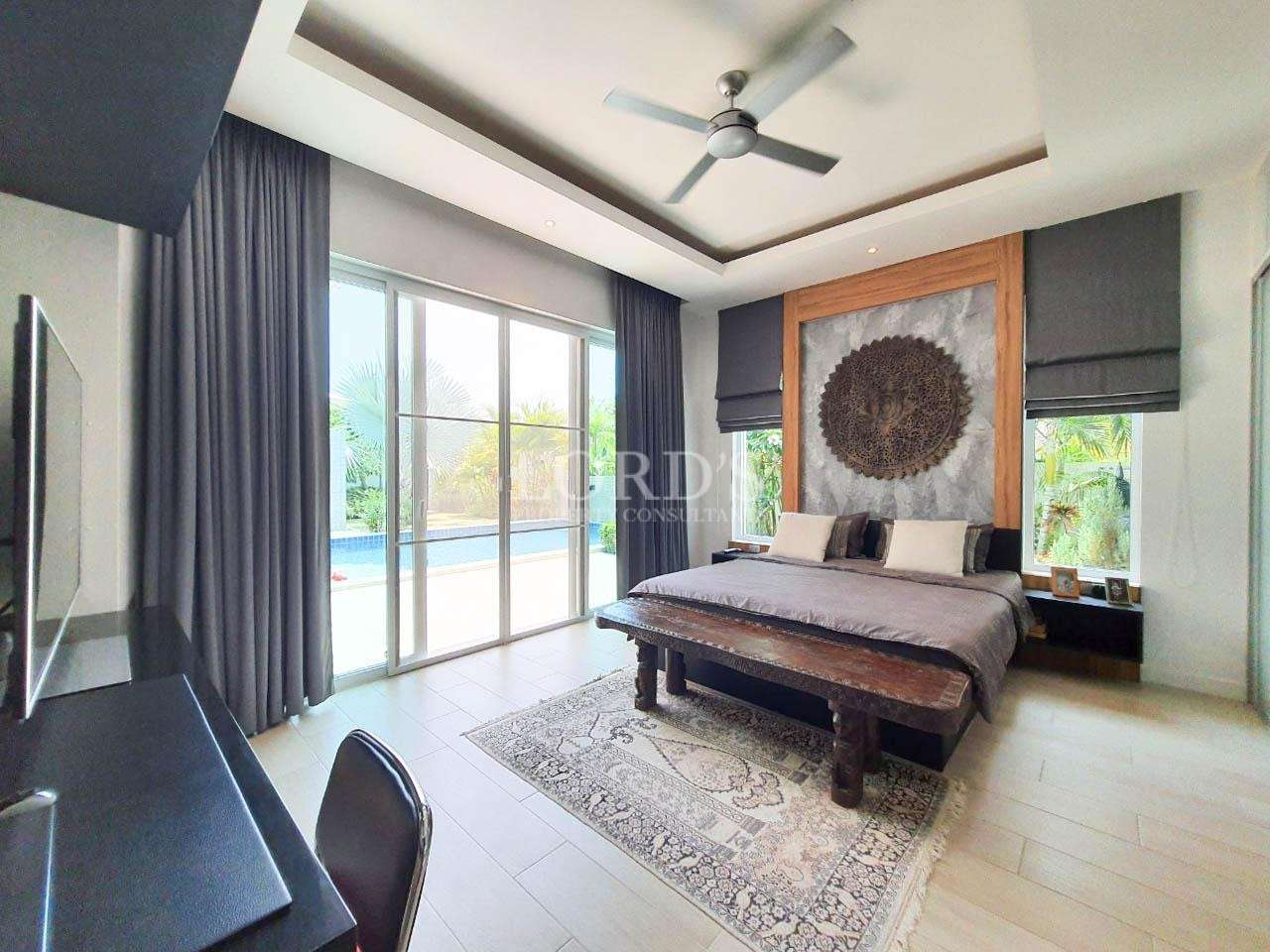 Bedroom with seating area and large windows