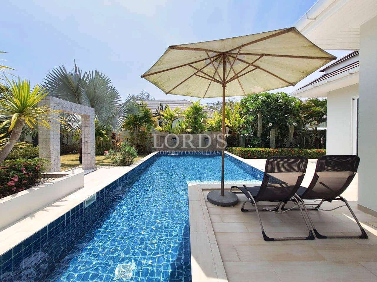 Poolside with sun loungers and umbrella