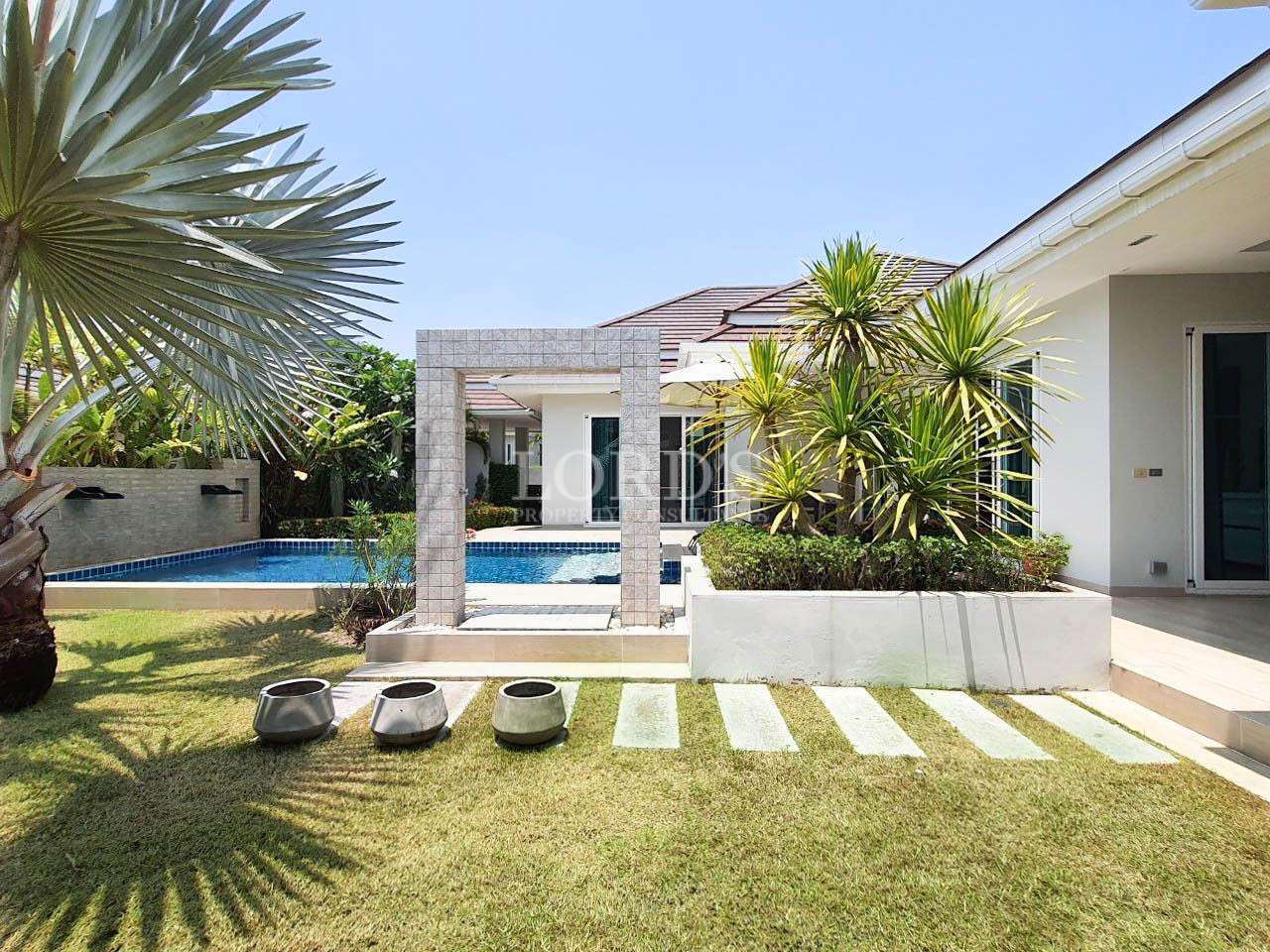 Villa exterior with lawn and stepping stones