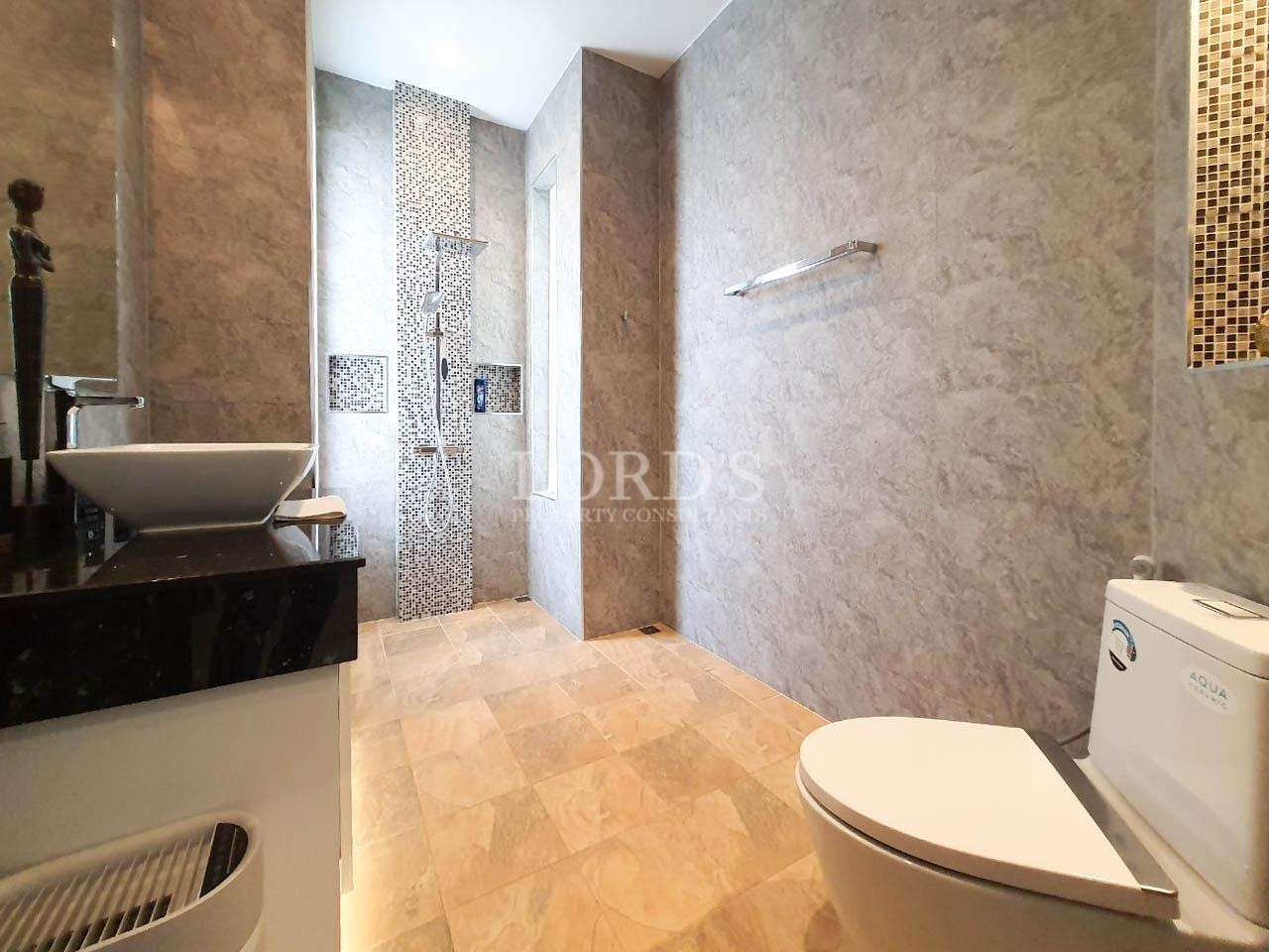 Bathroom with shower and marble wall