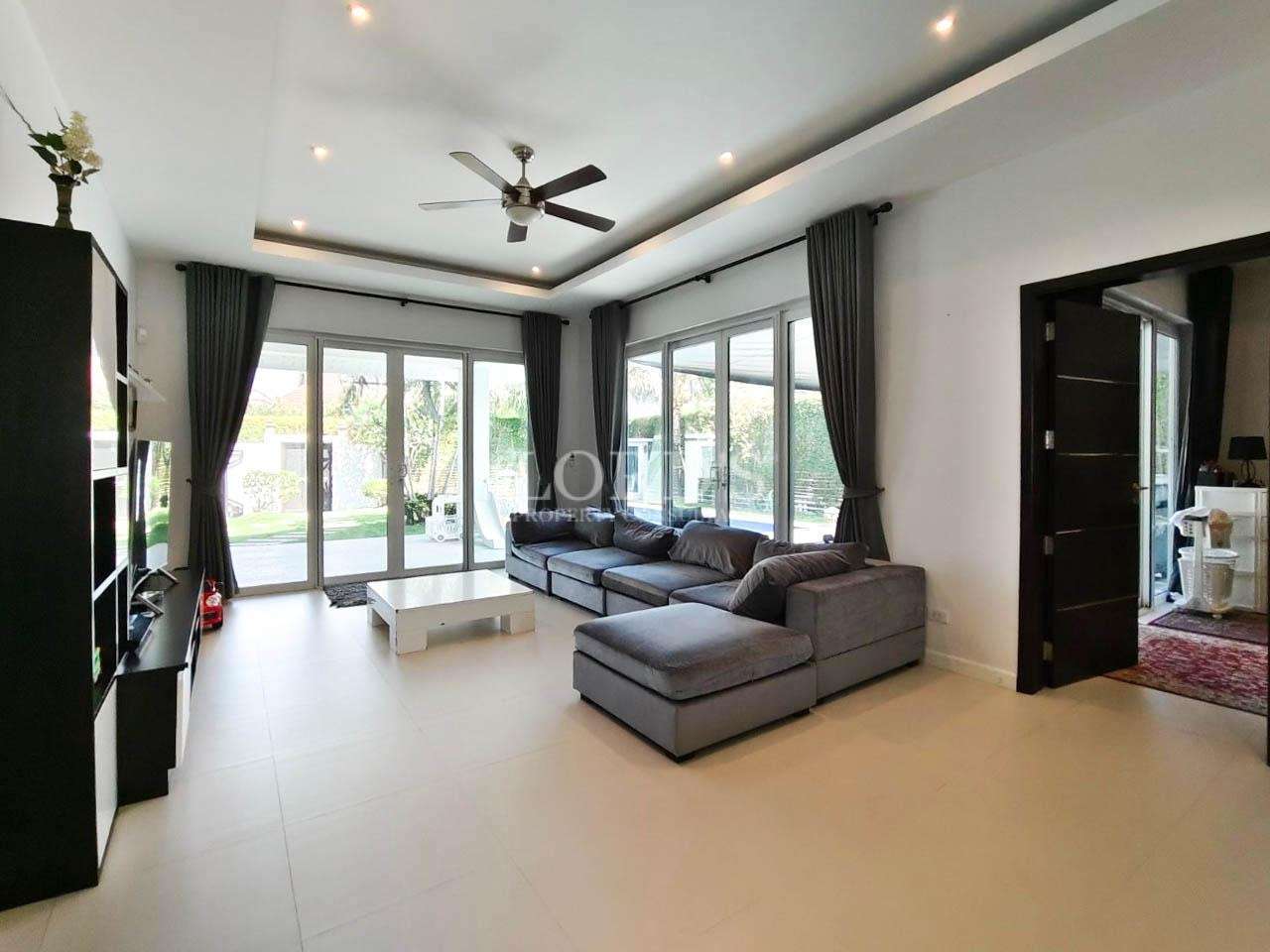 Living room with ceiling fan and large windows