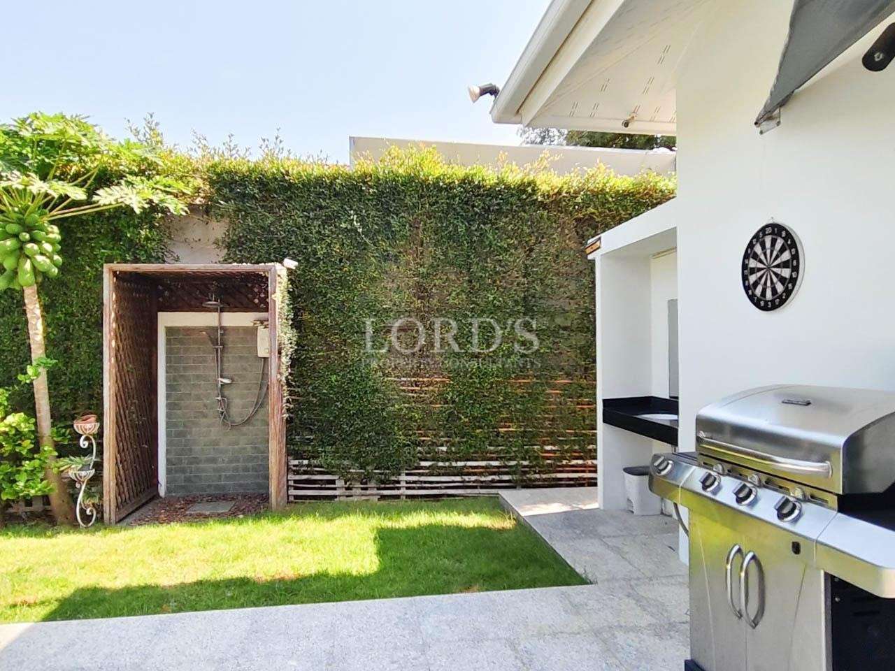 Luxury villa garden entrance with green hedge wall