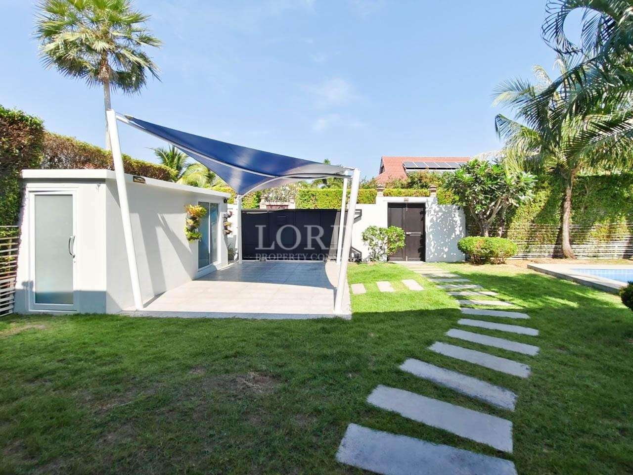 Villa garden with green lawn and stepping stones