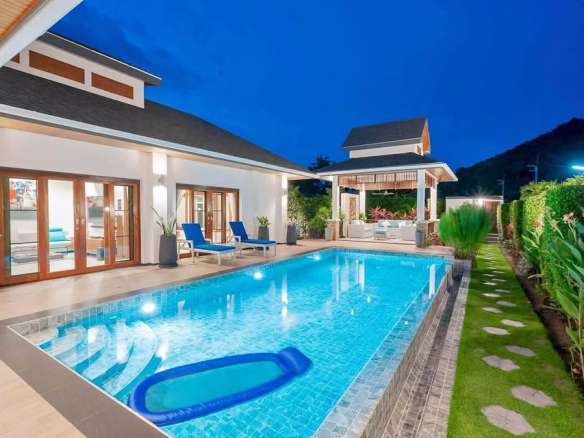 Pool at night with lighting and villa