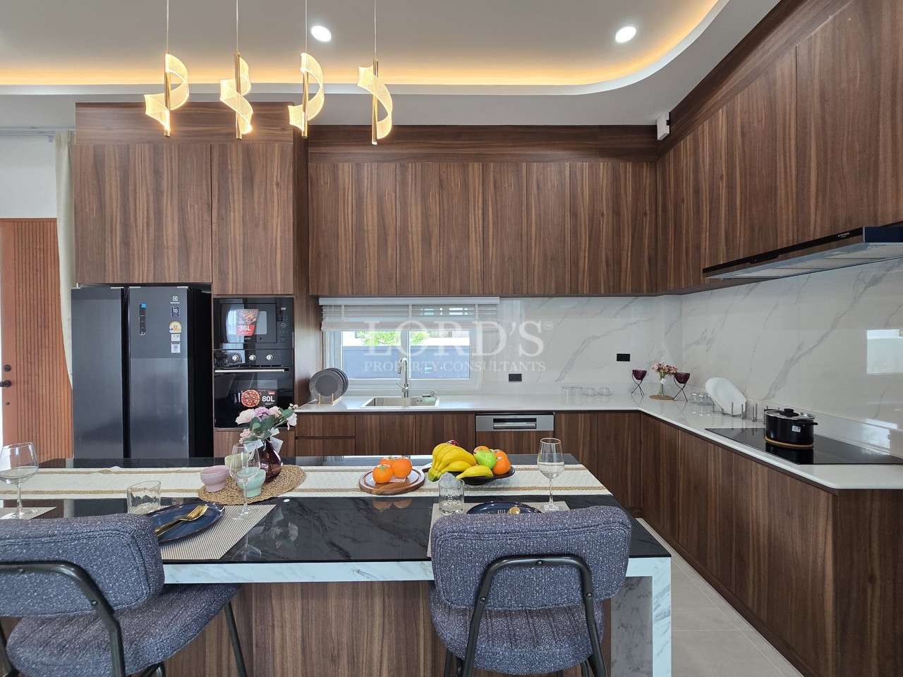 Modern kitchen with wood cabinetry, marble backsplash, and island with bar seating.