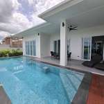 Modern white house with covered patio and rectangular swimming pool with built-in steps.