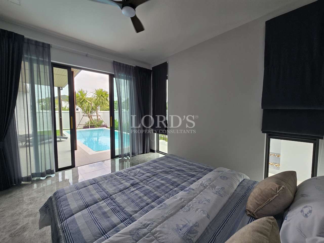 Modern bedroom with sliding glass doors opening to a private pool.
