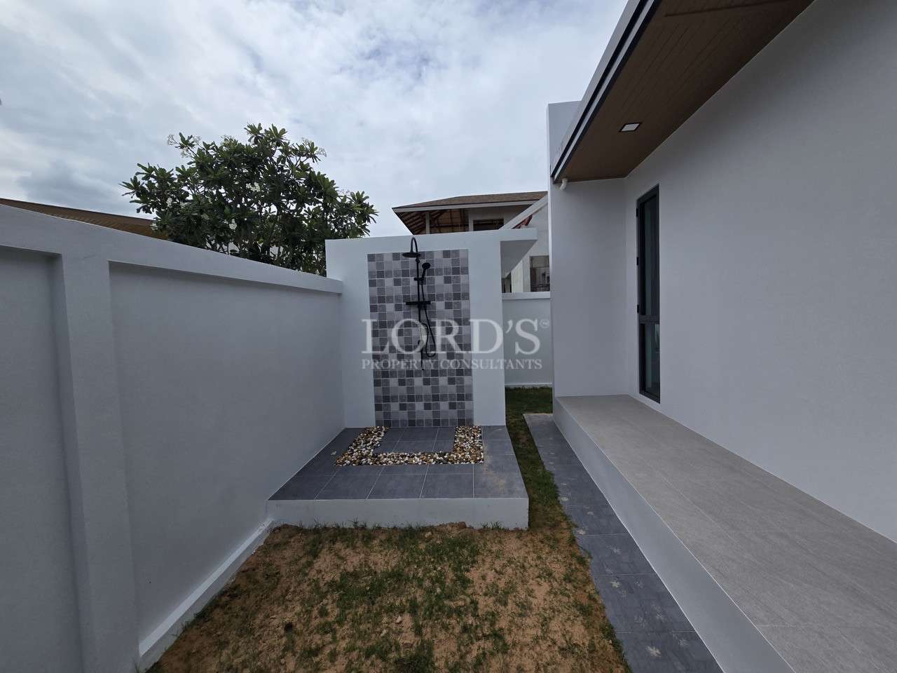 Outdoor shower area with tiled wall in a modern villa