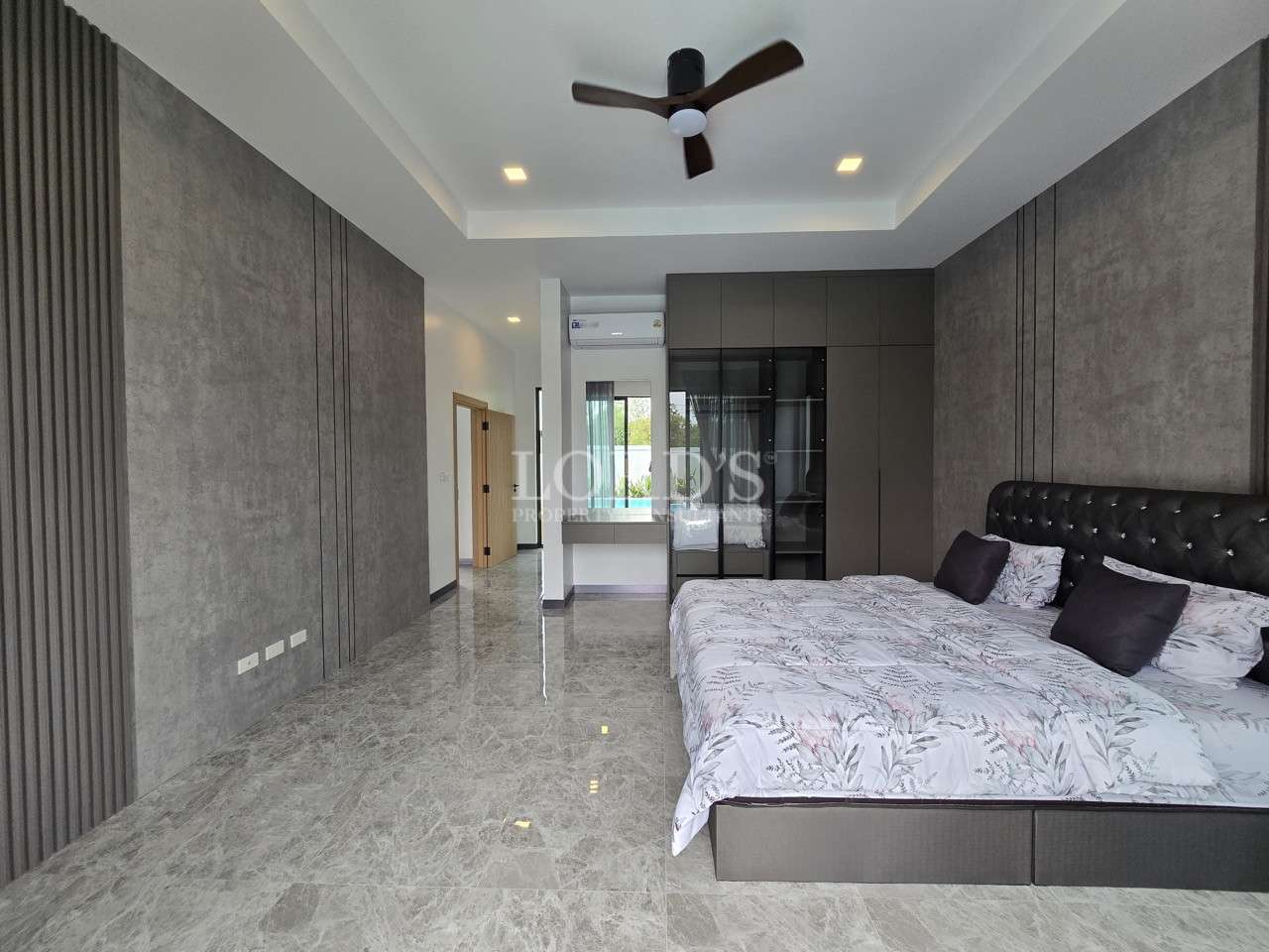 Modern master bedroom with king-size bed, built-in wardrobe, and ceiling fan