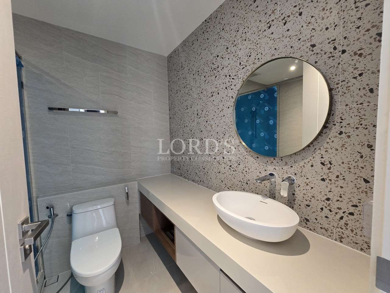 Modern bathroom with circular mirror.