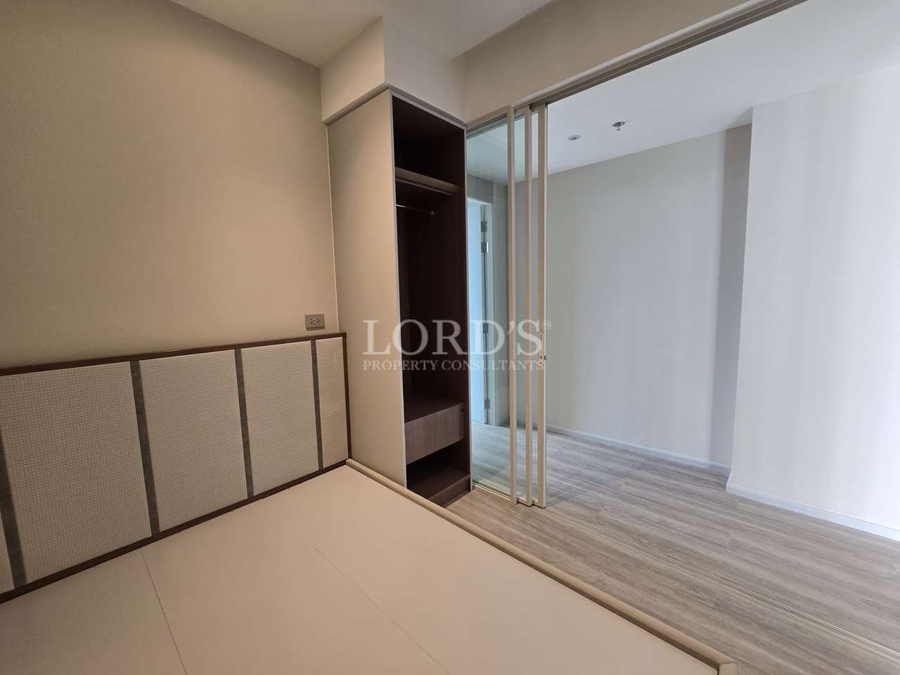Modern bedroom with built-in wardrobe, sliding partition, and wood-look flooring