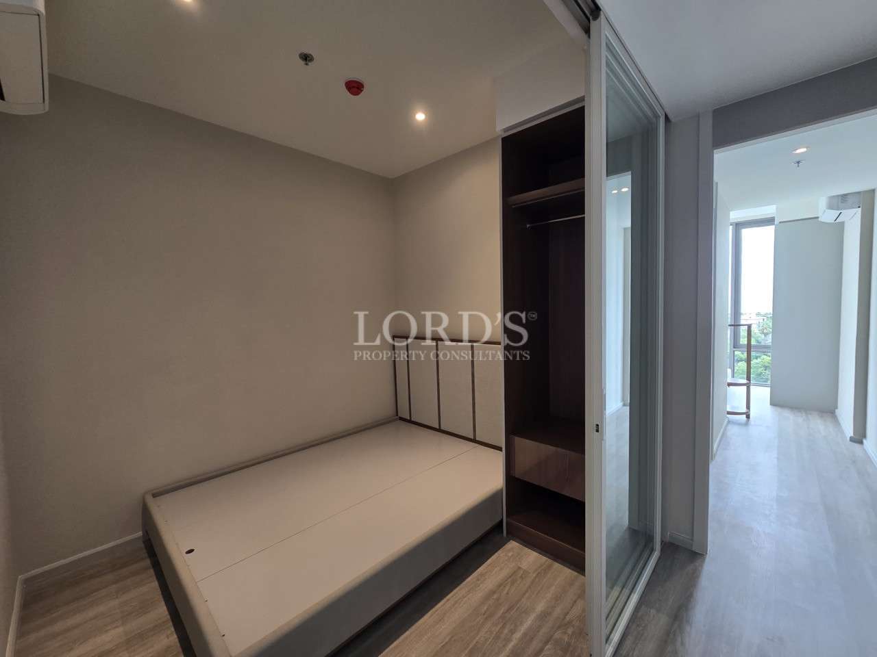 Modern bedroom with built-in wardrobe, sliding glass door, and natural light