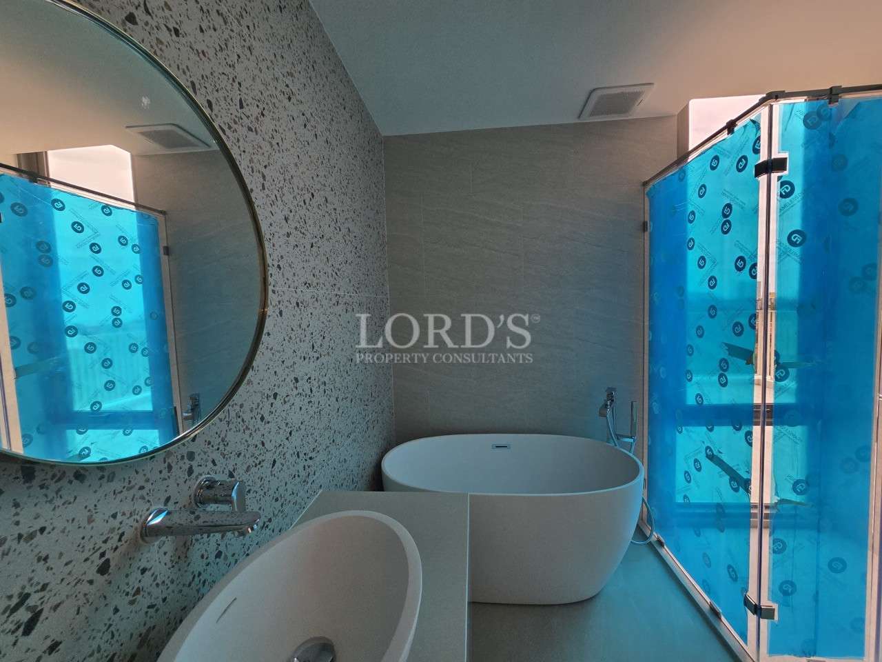 Modern luxury bathroom with freestanding bathtub, walk-in glass shower, and round mirror