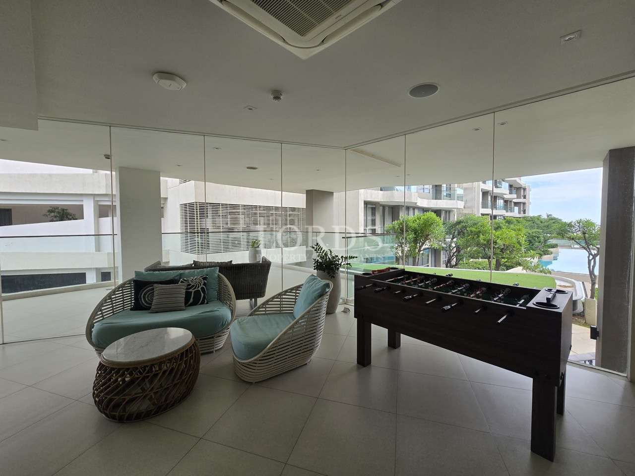 Condominium common lounge with seating area, foosball table, and garden view