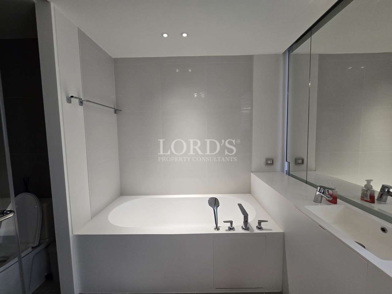 Modern bathroom with built-in bathtub, vanity sink, and wall mirror