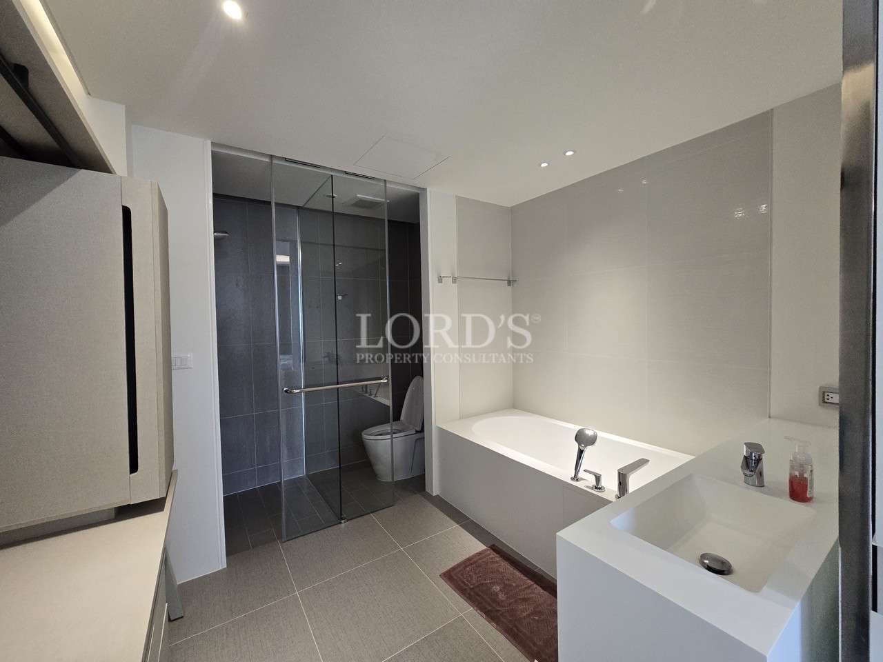 Modern bathroom with bathtub, glass shower enclosure, and vanity sink