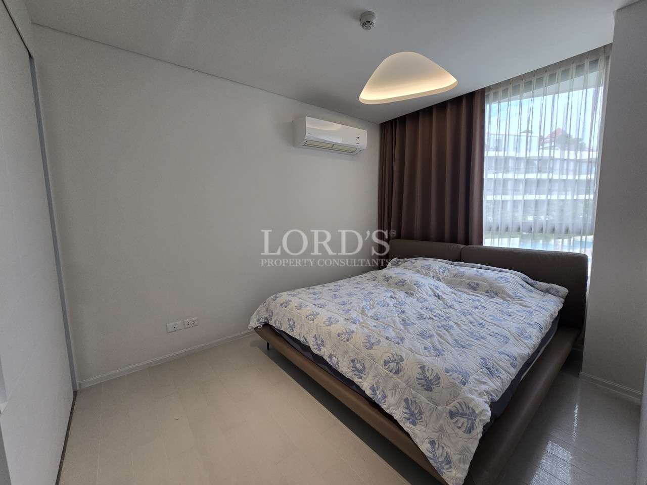 Modern bedroom with double bed, air conditioning, and large window