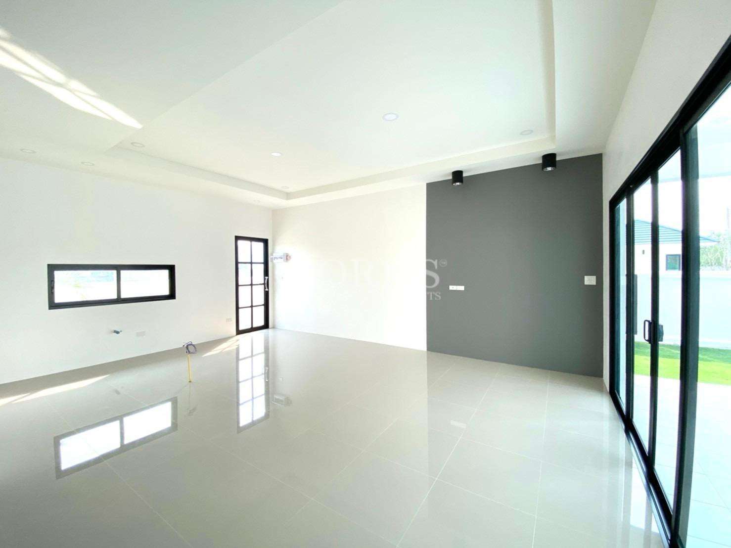 Modern open-plan living room with glossy tiled floor and sliding glass doors.