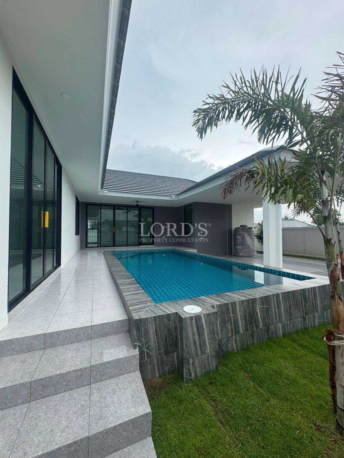 Modern private pool villa with covered terrace and landscaped garden