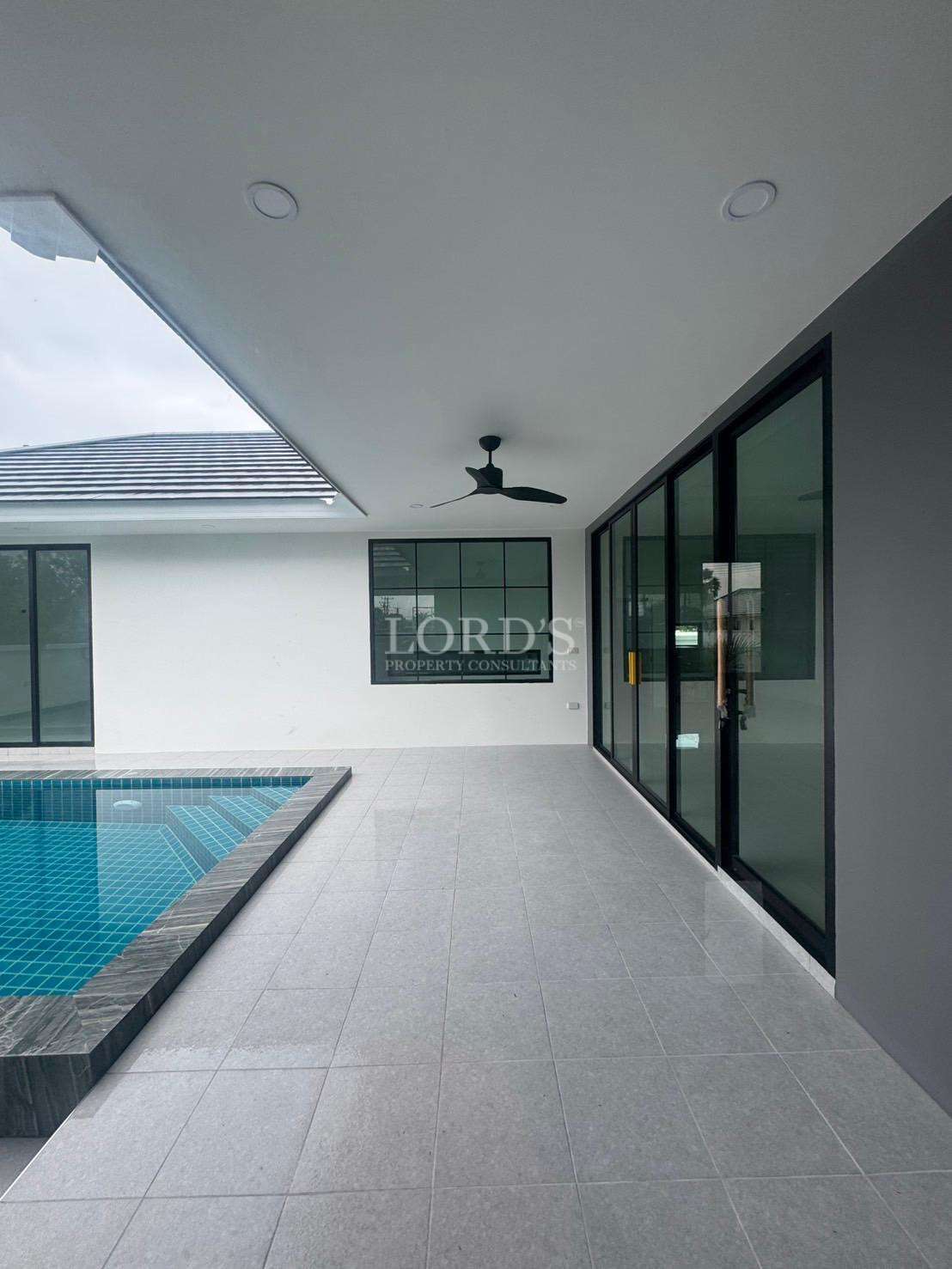 Covered poolside terrace with modern ceiling fan and sliding glass doors