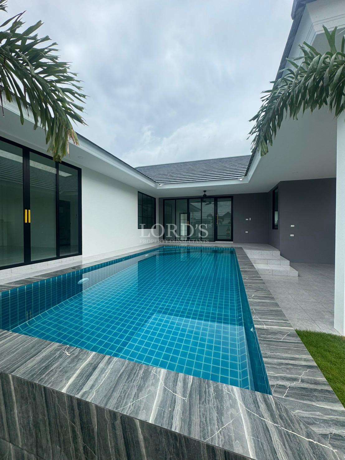 Modern private pool villa with tiled swimming pool and contemporary exterior design